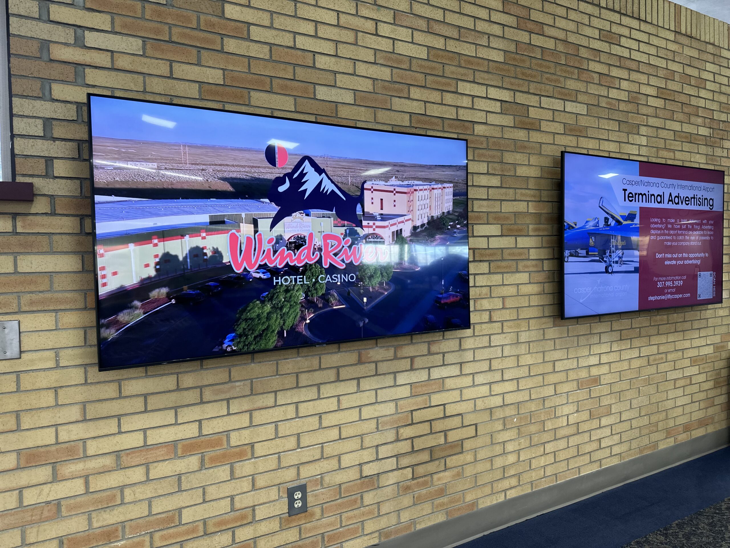 Digital advertising monitor mounted on a terminal wall at Casper/Natrona County International Airport